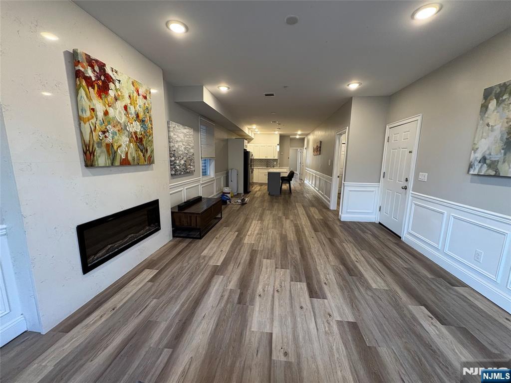 274 Governor Street, Unit 2 Paterson, NJ 07501 - Photo 3 of 15 a view of a living room a dining room with wooden floor and a fireplace