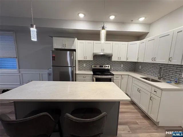 a kitchen with kitchen island a sink appliances and cabinets
