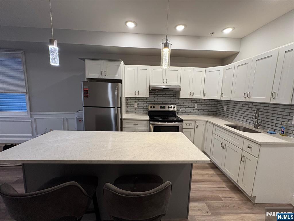 274 Governor Street, Unit 2 Paterson, NJ 07501 - Photo 4 of 15 a kitchen with kitchen island a sink appliances and cabinets
