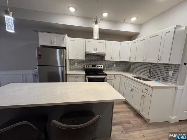 a kitchen with kitchen island a sink stainless steel appliances and counter space