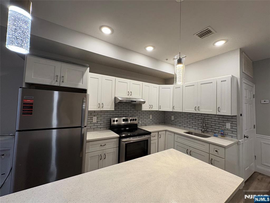 274 Governor Street, Unit 2 Paterson, NJ 07501 - Photo 6 of 15 a kitchen with granite countertop a refrigerator stove top oven and sink