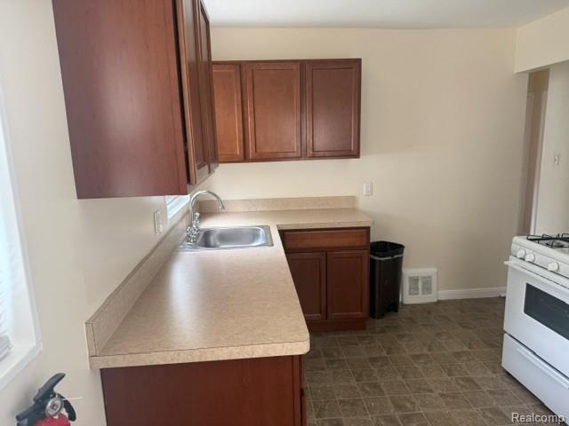 970 Champaign Road Lincoln Park, MI 48146 - Photo 7 of 28 Kitchen featuring white range with gas stovetop and light countertops