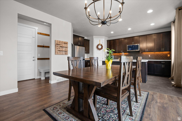 3359 Eurasian Crane Road Clinton, UT 84015 - Photo 11 of 71 Dining area featuring hanging lights and dark wood-style flooring
