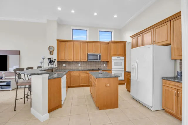 a kitchen with stainless steel appliances granite countertop a refrigerator and a stove top oven