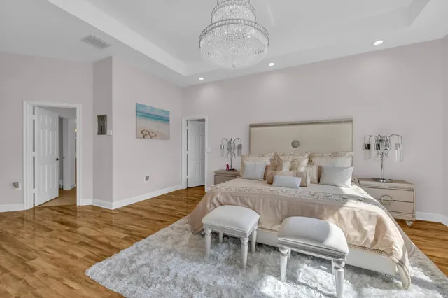 a spacious bedroom with a bed and a flat screen tv