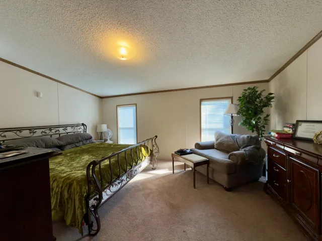 a bed sitting in a bedroom and dining room