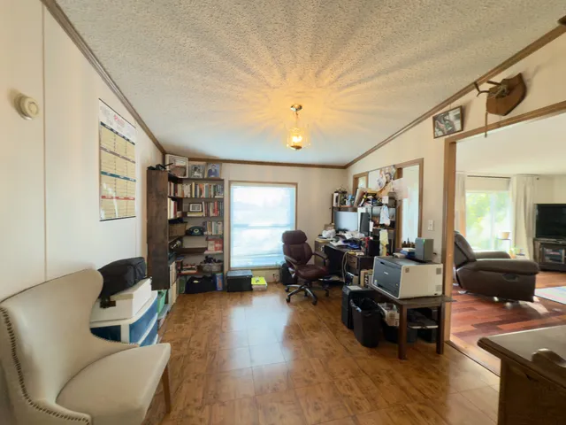 a bedroom with a bed ceiling fan and a wooden floor
