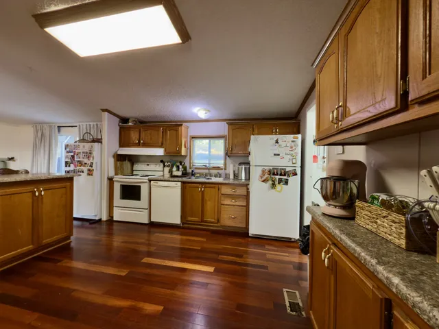 a kitchen with stainless steel appliances granite countertop sink stove top oven and refrigerator