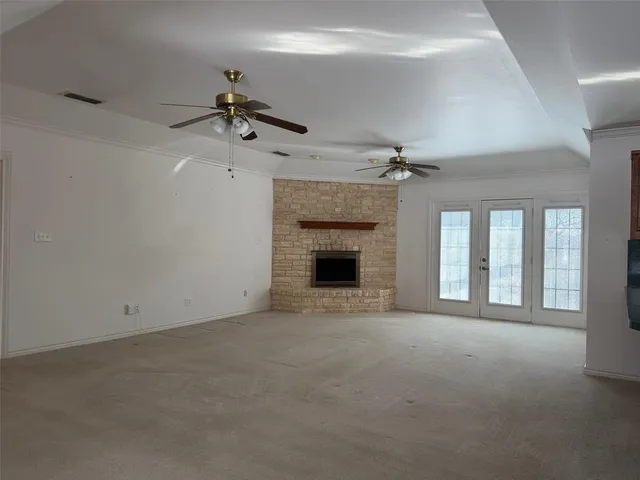 a view of an empty room with a fireplace and a window