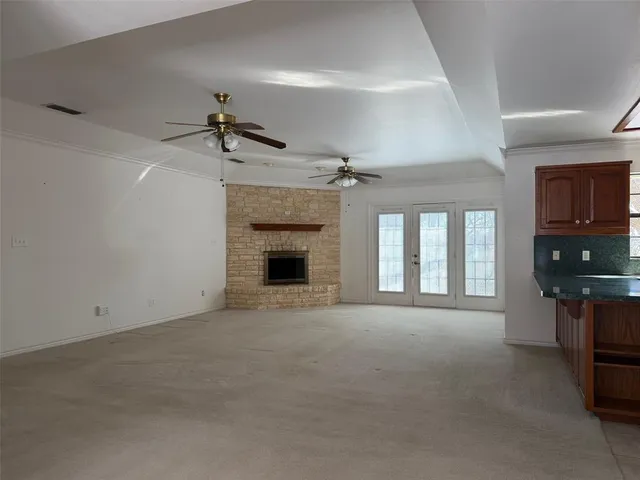 a view of an empty room with a fireplace and a window