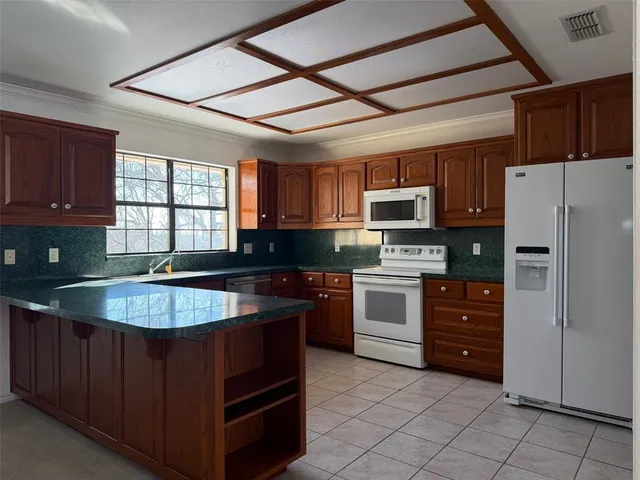 a kitchen with granite countertop a stove cabinets and stainless steel appliances