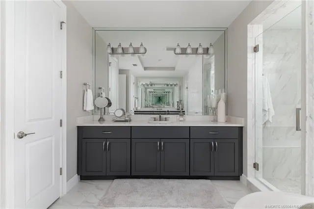 a bathroom with a sink a toilet a mirror a bathtub and shower