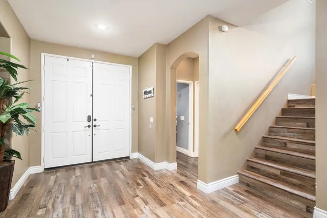 a view of a hallway with wooden floor and staircase