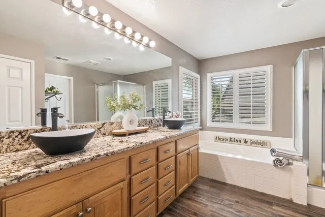 a bathroom with a granite countertop sink and a large mirror