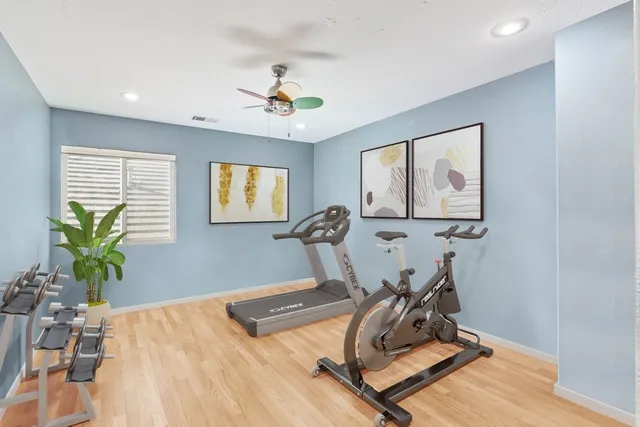 a room with gym equipment and a wooden floor