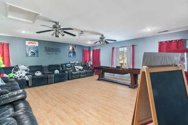 a living room with furniture a chandelier and a flat screen tv