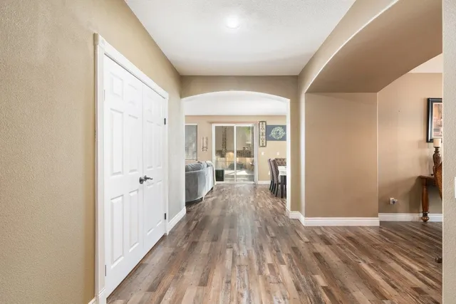 a view of a hallway with wooden floor and furniture