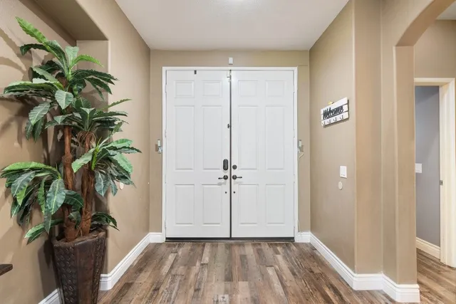 a view of a hallway with wooden floor and a potted plant