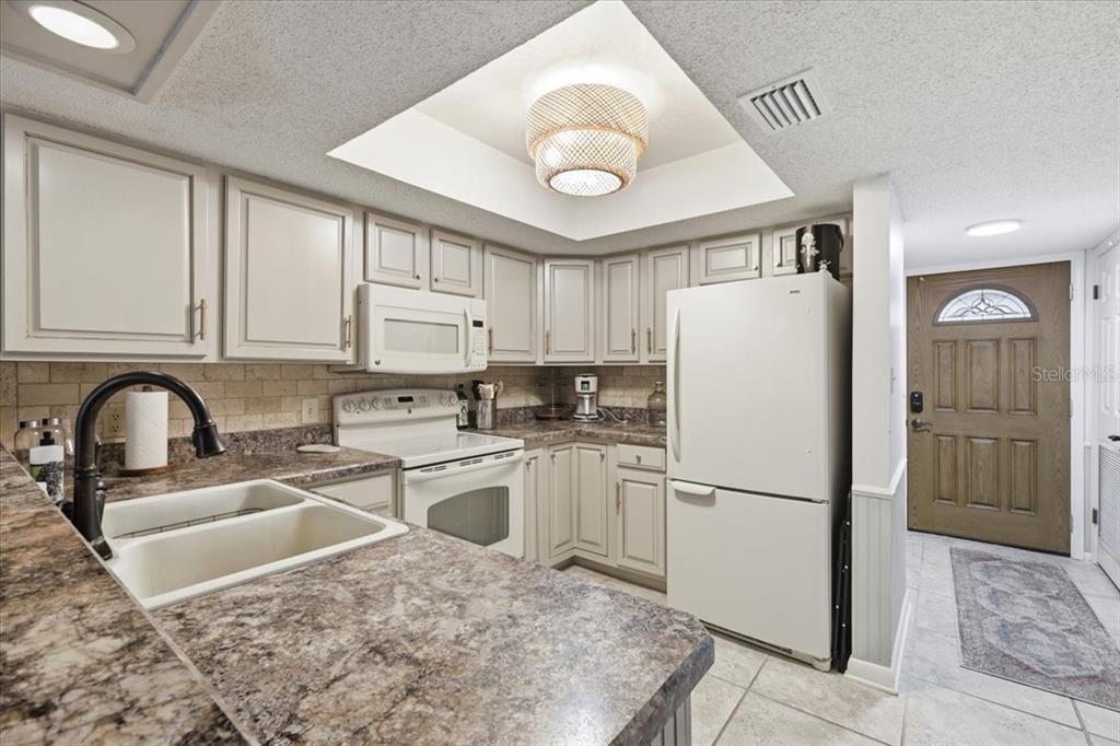 2329 River Ridge Road, Unit 2 DeLand, FL 32720 - Photo 4 of 17 a kitchen with granite countertop a refrigerator a stove a sink and cabinets