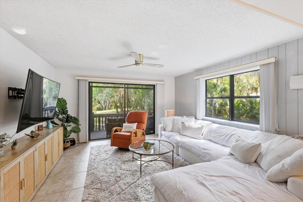 2329 River Ridge Road, Unit 2 DeLand, FL 32720 - Photo 6 of 17 a living room with furniture flat screen tv and a large window