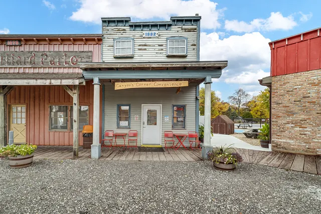 a kitchen with stainless steel appliances kitchen island granite countertop a dining table chairs refrigerator and sink