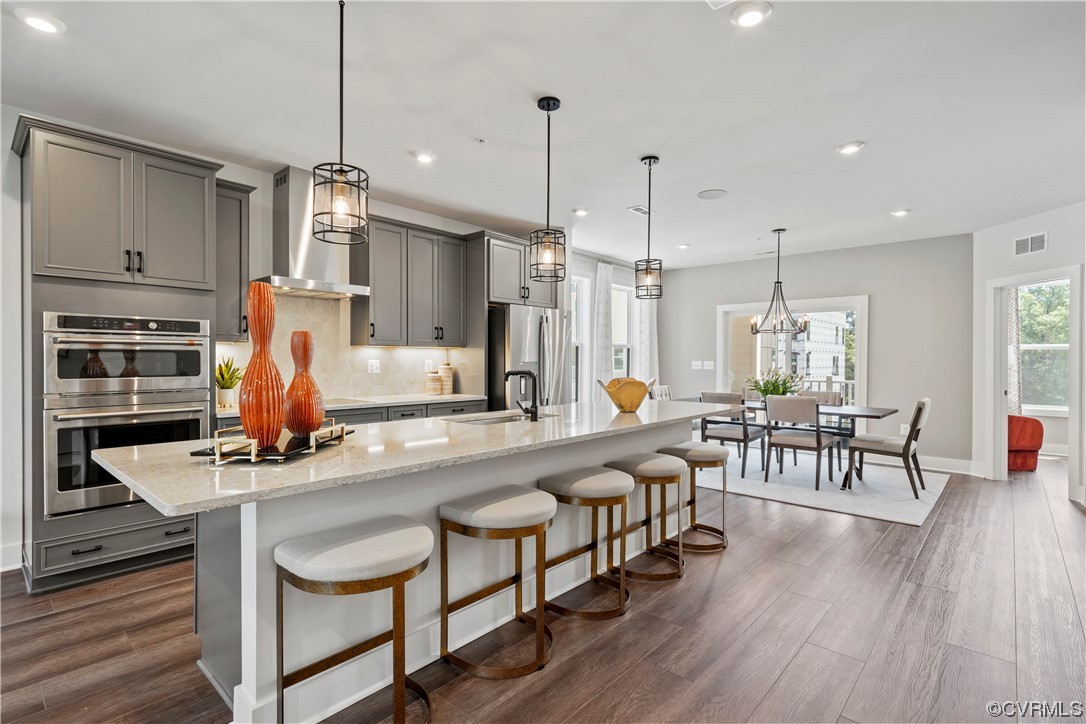 a kitchen with stainless steel appliances kitchen island granite countertop a table chairs and a chandelier