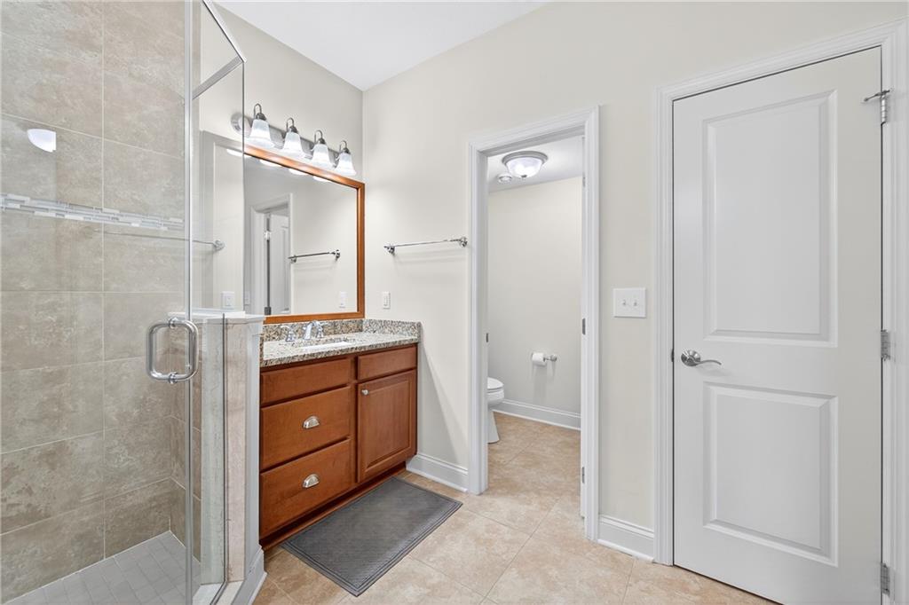 4709 Wallingford Street Pittsburgh, PA 15213 - Photo 21 of 39 a bathroom with a granite countertop sink a mirror and a shower