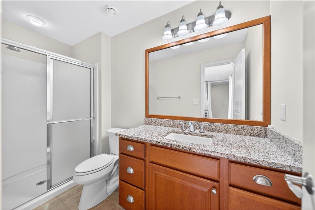 4709 Wallingford Street Pittsburgh, PA 15213 - Photo 28 of 39 a bathroom with a granite countertop sink a toilet and a mirror