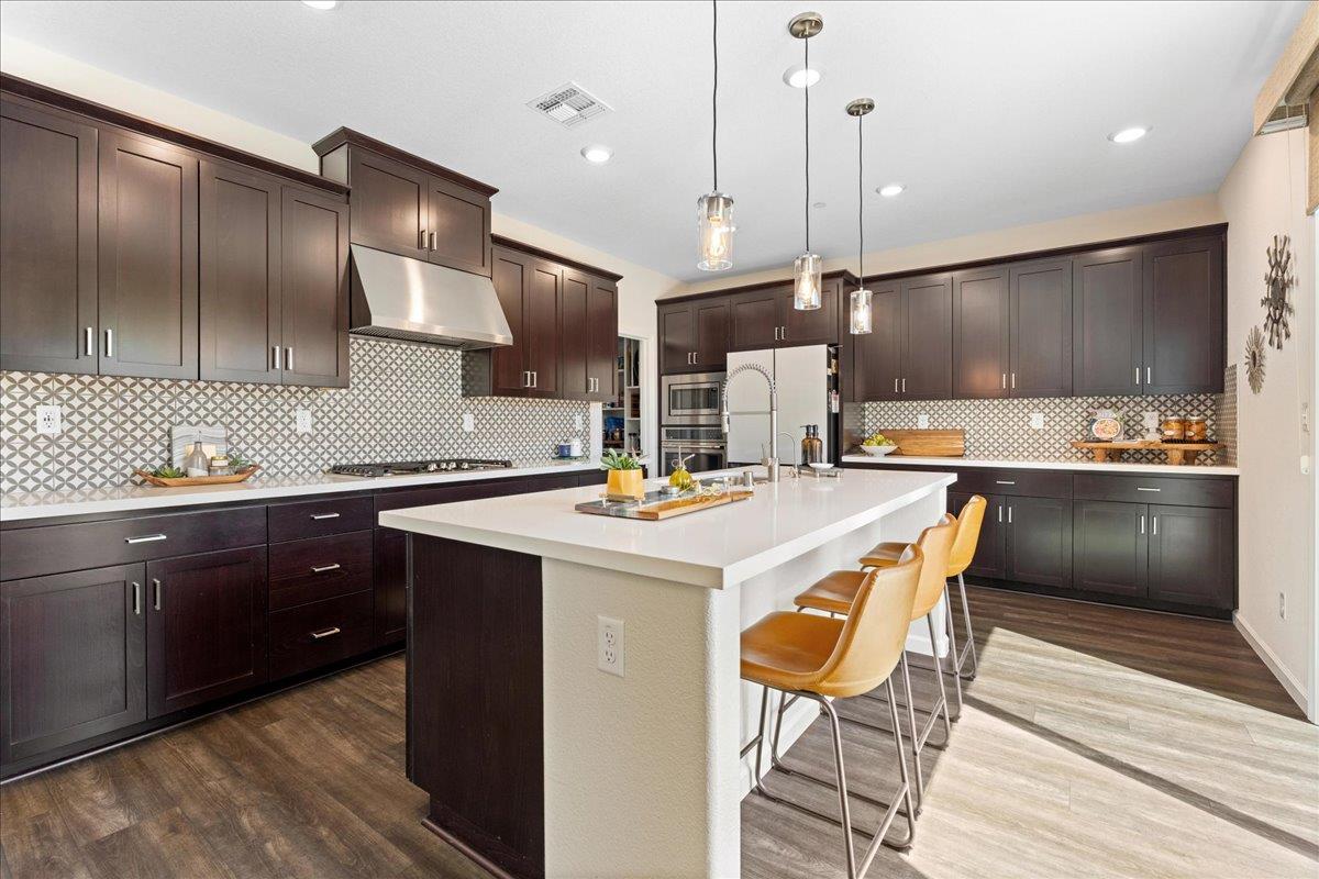 823 Riley Lane Lincoln, CA 95648 - Photo 8 of 52 a kitchen with stainless steel appliances kitchen island granite countertop a sink a stove and a refrigerator