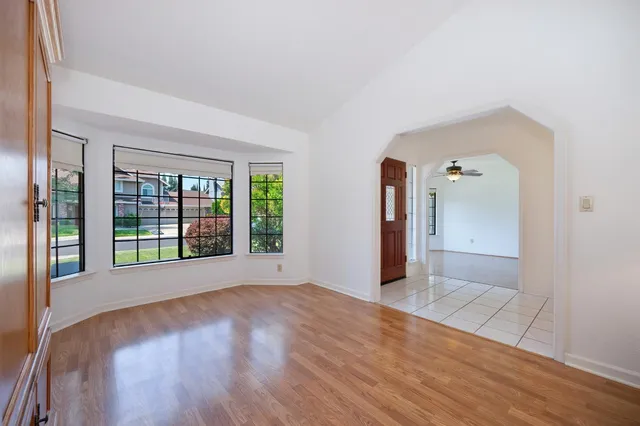 a view of a big room with wooden floor and a chandelier fan