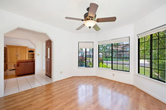a view of a room with wooden floor and a ceiling fan