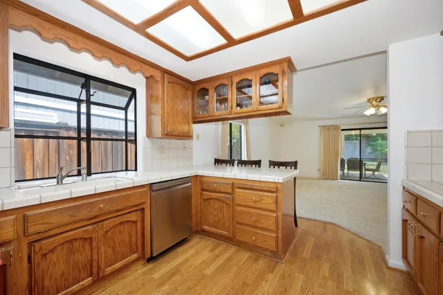 a hallway with a stove a microwave and a book shelf