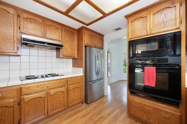a kitchen with stainless steel appliances granite countertop a refrigerator microwave and sink