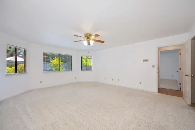 a view of a backyard with table and chairs under an umbrella with wooden fence
