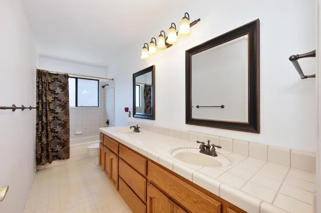 an empty room with windows and ceiling fan