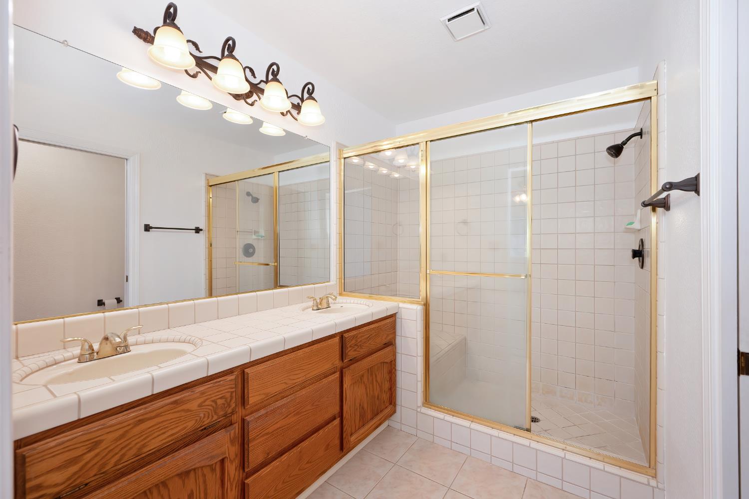 5408 East Brook Way Elk Grove, CA 95758 - Photo 36 of 53 a bathroom with a double vanity sink mirror and shower