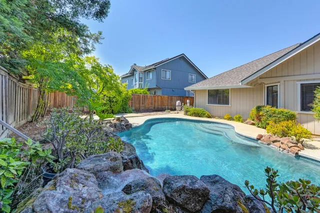 a view of a backyard with swimming pool