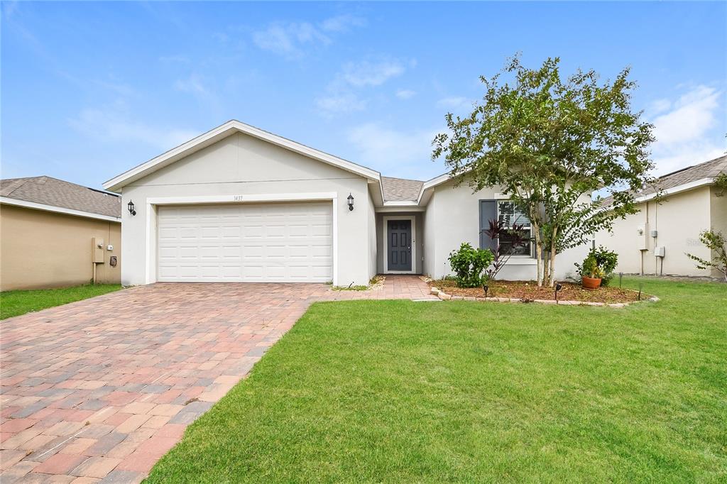 a front view of a house with a yard and garage