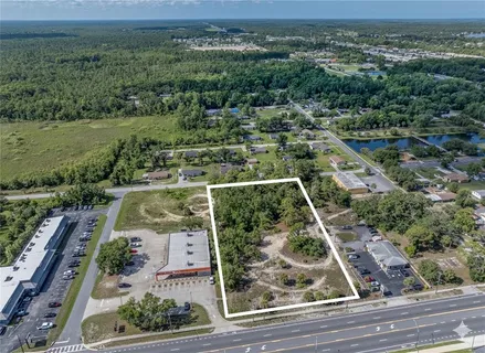 an aerial view of residential houses with outdoor space and trees