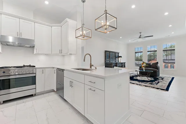 a kitchen with stainless steel appliances granite countertop white cabinets and a stove