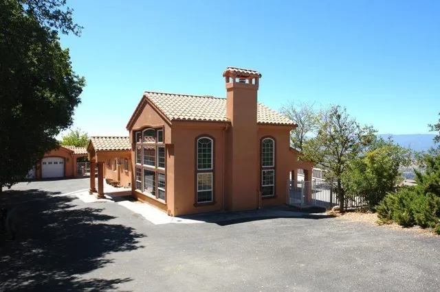 a view of a house with many windows next to a yard