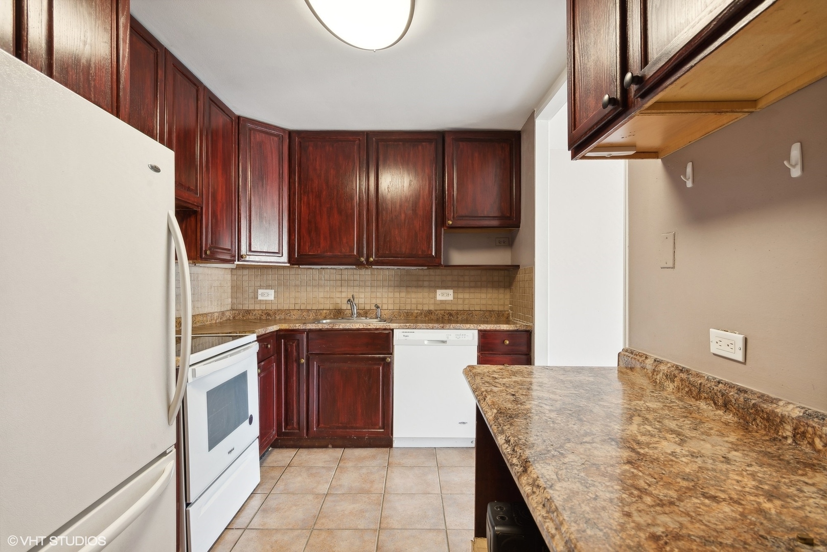 5445 North Sheridan Road, Unit 403 Chicago, IL 60640 - Photo 3 of 11 a kitchen with stainless steel appliances granite countertop a sink and cabinets