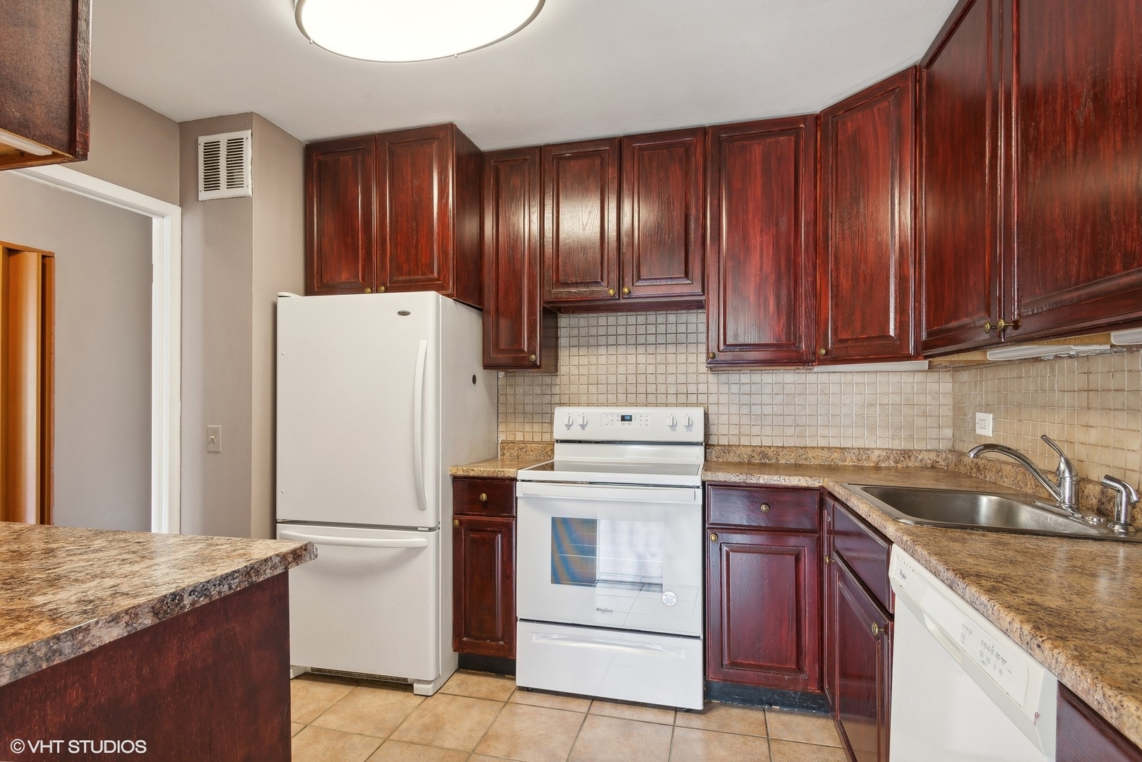 5445 North Sheridan Road, Unit 403 Chicago, IL 60640 - Photo 4 of 11 a kitchen with a sink a stove and refrigerator