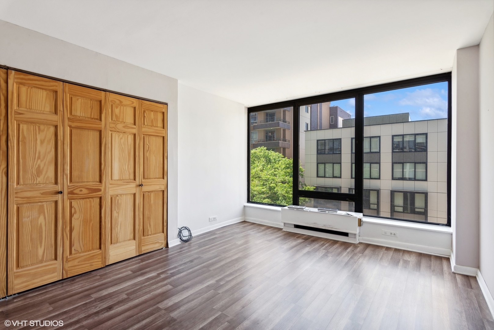 5445 North Sheridan Road, Unit 403 Chicago, IL 60640 - Photo 5 of 11 an empty room with wooden floor and windows