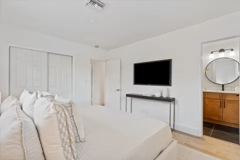 a bedroom with a bed and a flat screen tv