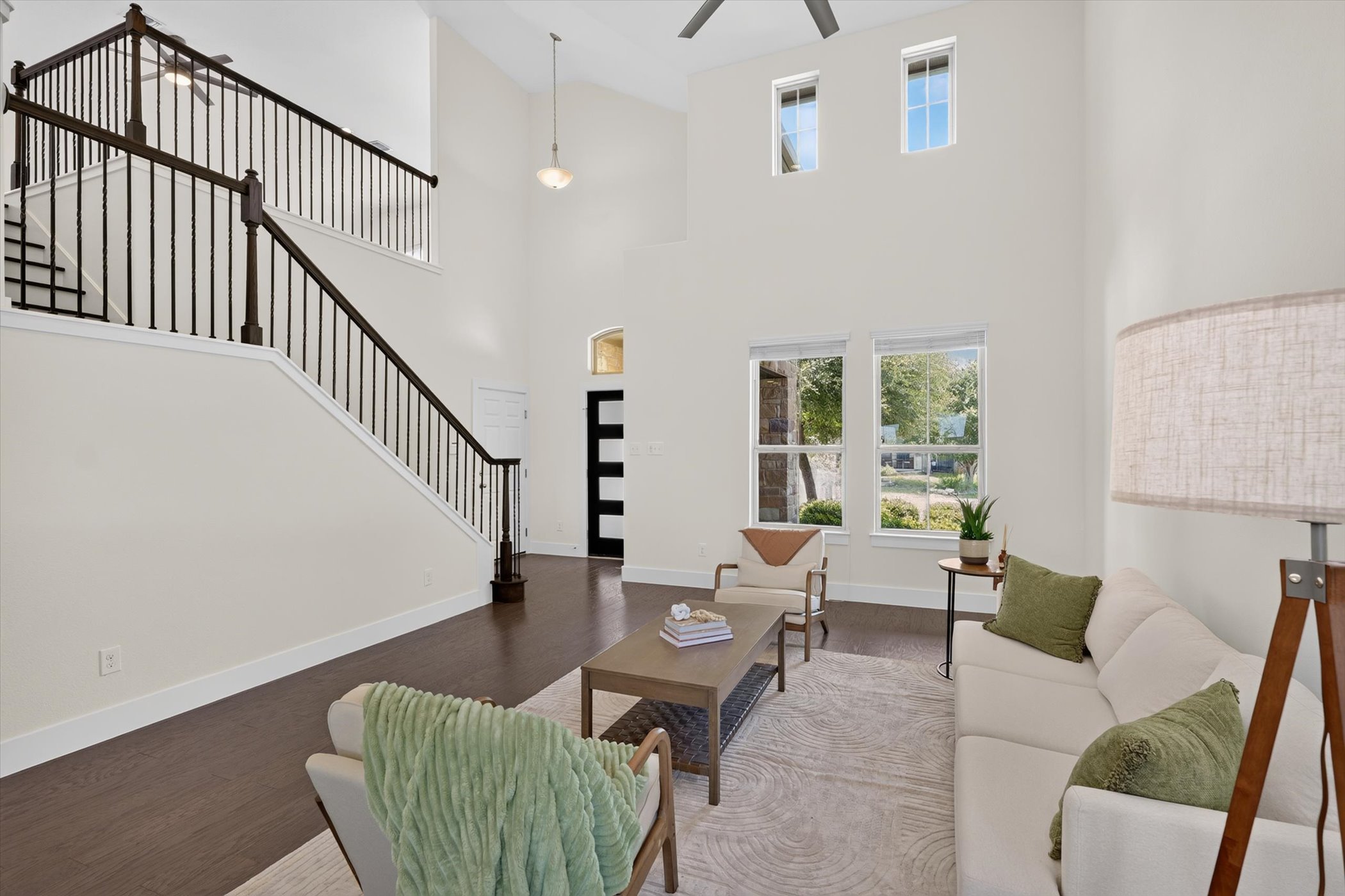 2004 Garretts Way Manchaca, TX 78652 - Photo 8 of 35 Double-height ceilings and a dramatic staircase define this open, light-filled living area.