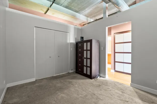 an empty room with closet and windows