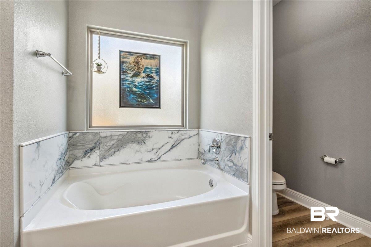 7022 Rocky Rd Loop Gulf Shores, AL 36542 - Photo 27 of 59 Primary Full bath featuring a garden tub and wood finished floors