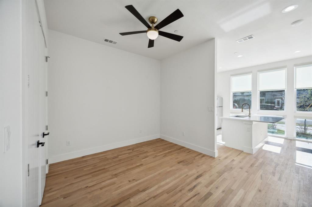 4907 Bryan Street Dallas, TX 75204 - Photo 12 of 21 an empty room with wooden floor and windows