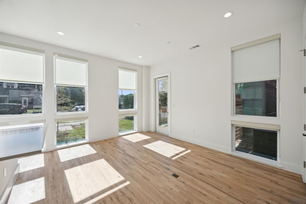 4907 Bryan Street Dallas, TX 75204 - Photo 13 of 21 a view of an empty room with window and wooden floor